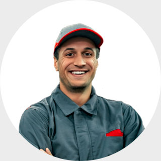 uśmiechnięty mężczyzna w kombinezonie roboczym ze skrzyżowanymi rękami